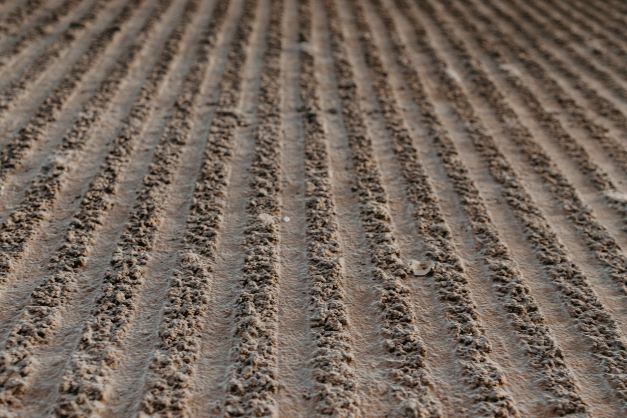 Detailed view of textured plowed field rows creating a rhythmic pattern.
